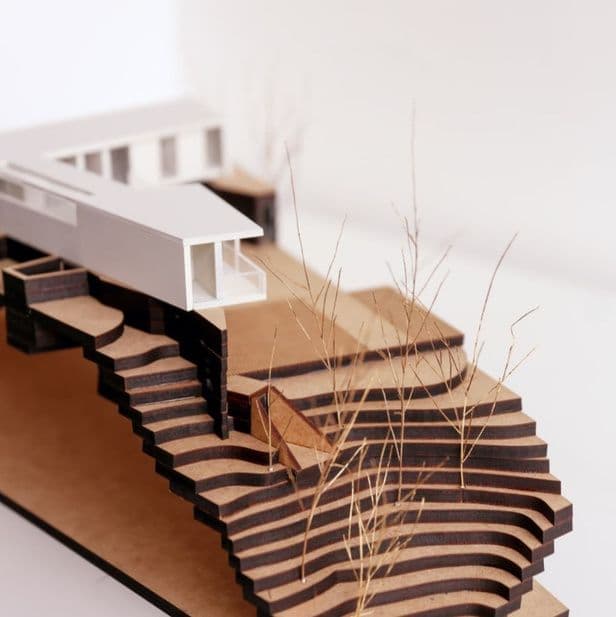 Maquete da Casa Gruna com volume branco sobre terreno escalonado de MDF