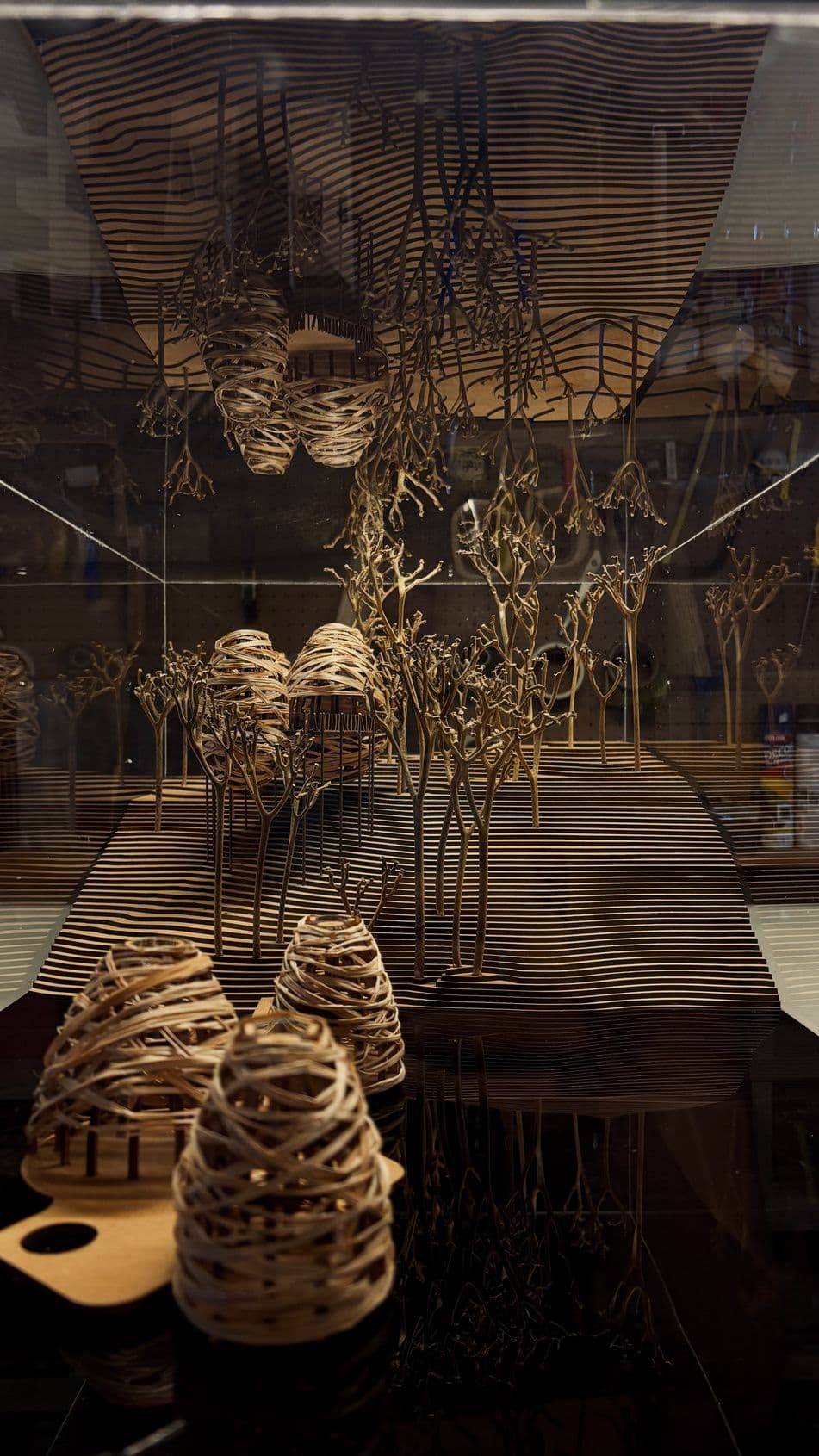 Mãos segurando um dos casulos de madeira da maquete Japiim